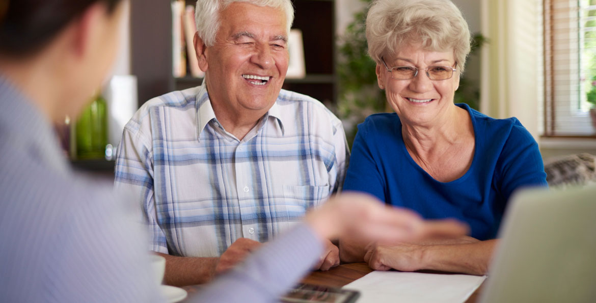 Couple senior souriant lors d’un rendez-vous – Plan d’Épargne Retraite AXA avec cadre fiscal avantageux