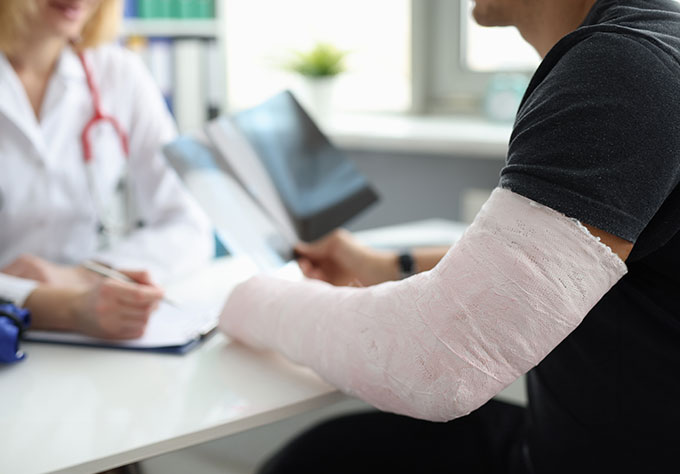 Médecin avec patient plâtré – Garantie accident AXA pour une protection financière au quotidien