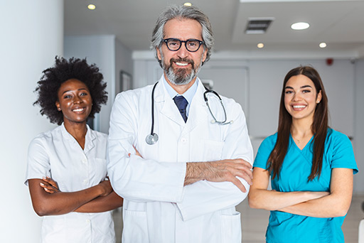 Trois professionnels de santé souriants en blouse – Mutuelle santé adaptée aux métiers médicaux