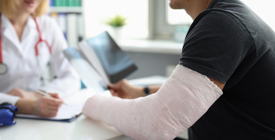 Médecin avec patient plâtré – Garantie accident AXA pour une protection financière au quotidien