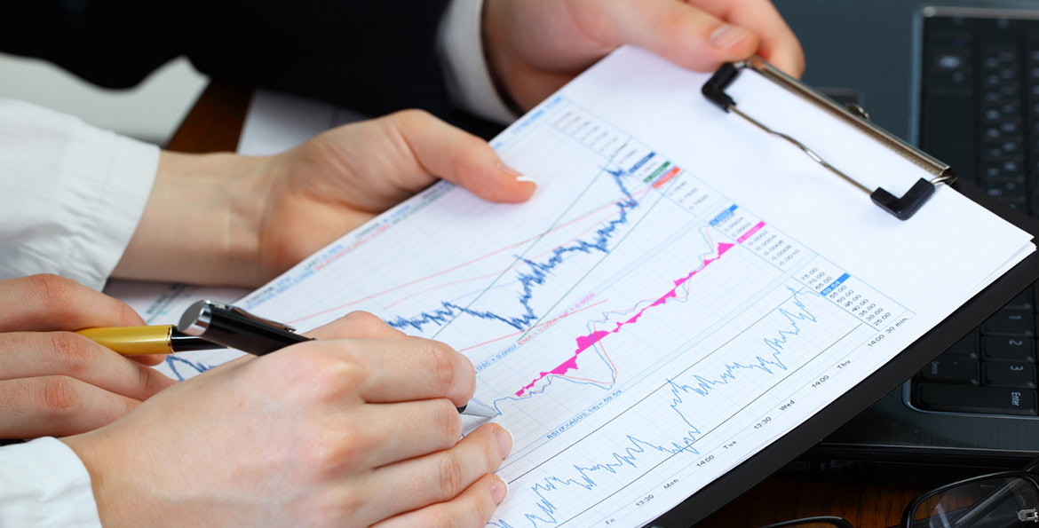 Main analysant un graphique boursier – Investir en bourse avec le PEA AXA