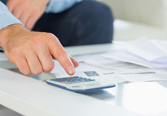 Main pointant un document financier – Compte à terme AXA pour sécuriser votre capital avec un taux connu